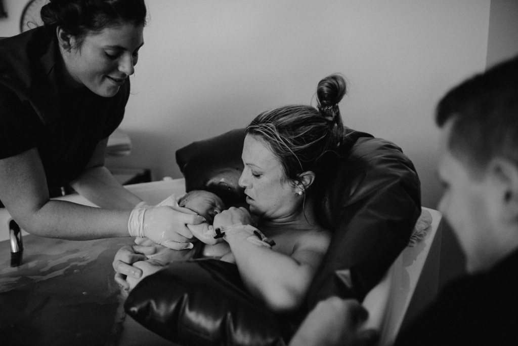 Mama hält frischgeborenes Baby im Arm
