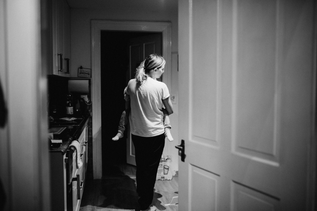 Mama mit Kind auf dem Arm in der Küche