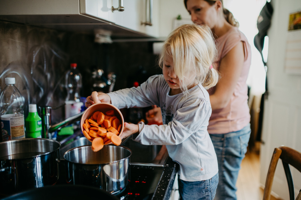 Mädchen am Karotten kochen