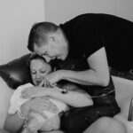 Foto aus einer Geburtsreportage wo die Eltern ihr Baby nach der Geburt im Arm halten und bestaunen